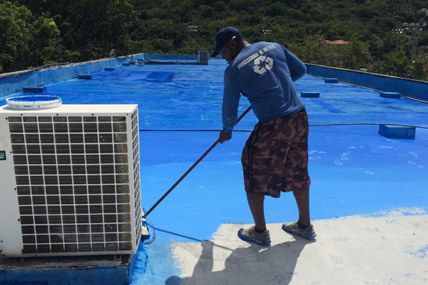 Flat roof installation. Heating and melting bitumen roofing felt